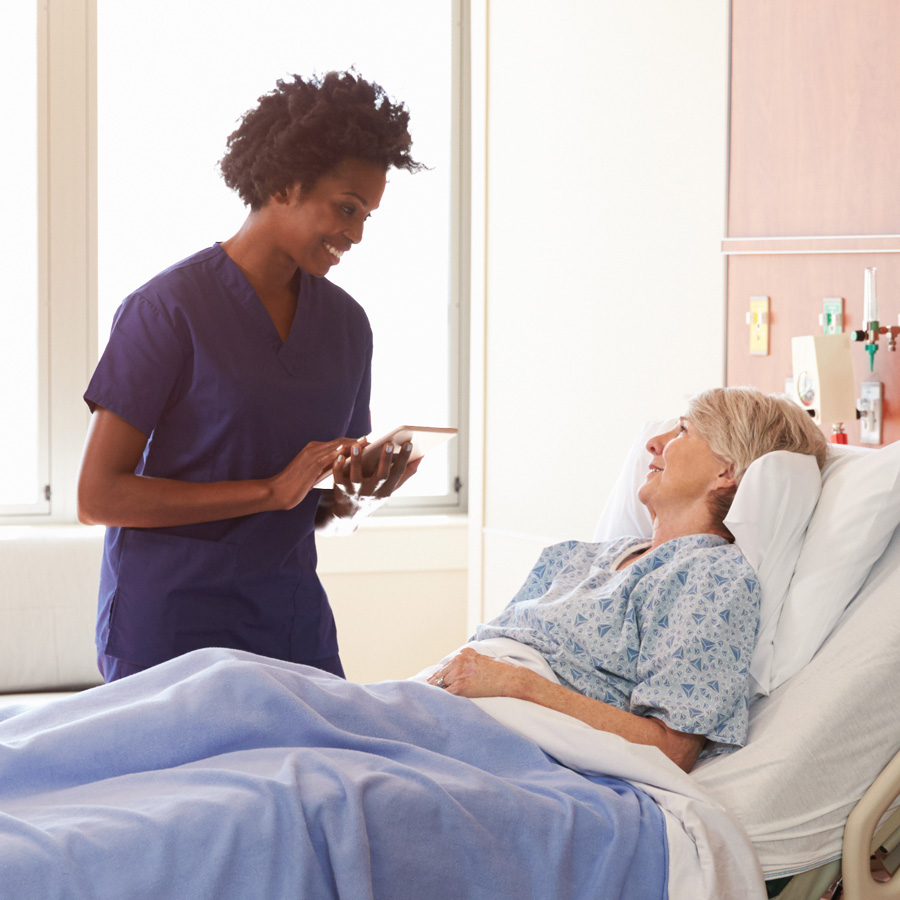 Nurse standing next to a patient's bedside, providing high-quality care